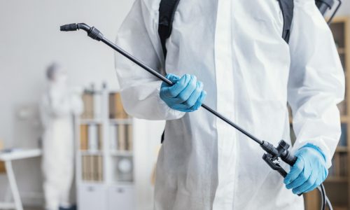 person-disinfecting-dangerous-area-while-wearing-protective-suit